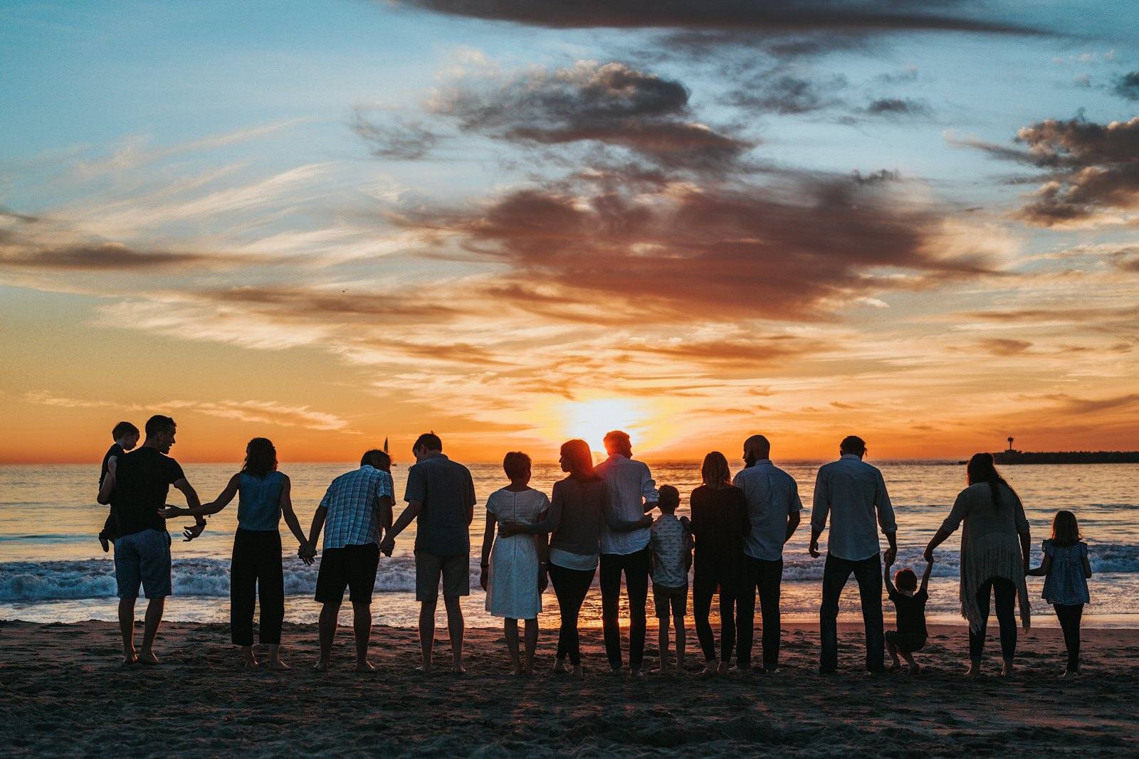 A family walking together on a beach at sunset
